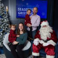 Parents with young brother and sister smile with Santa